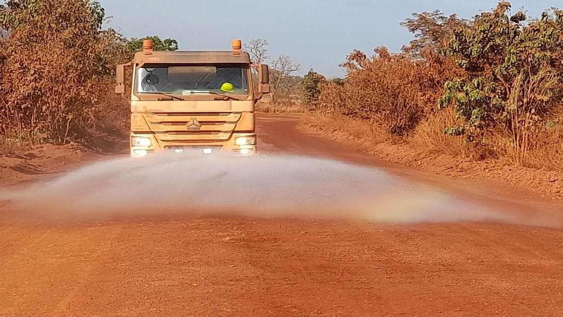 Camion-citerne arrosant une piste pour abattre la poussière